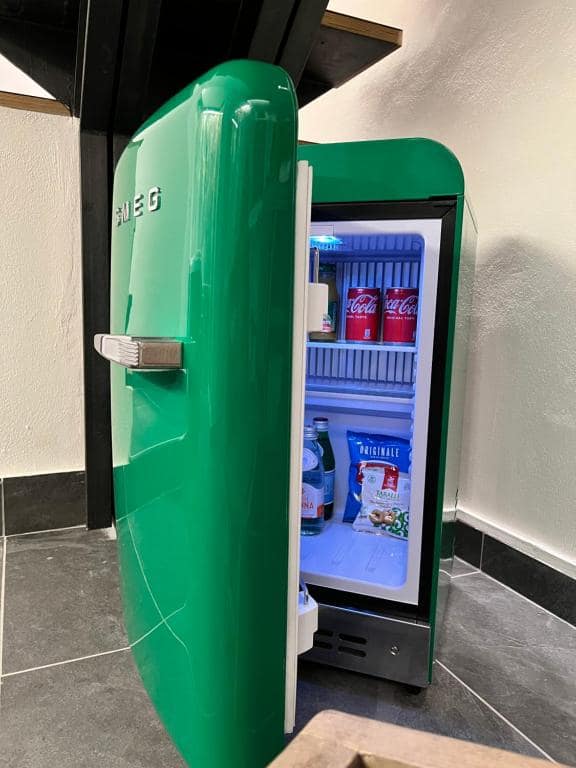 Minibar Smeg verde retrò della suite Marcello a Verona, aperto: Coca-Cola, acqua minerale e taralli italiani inclusi