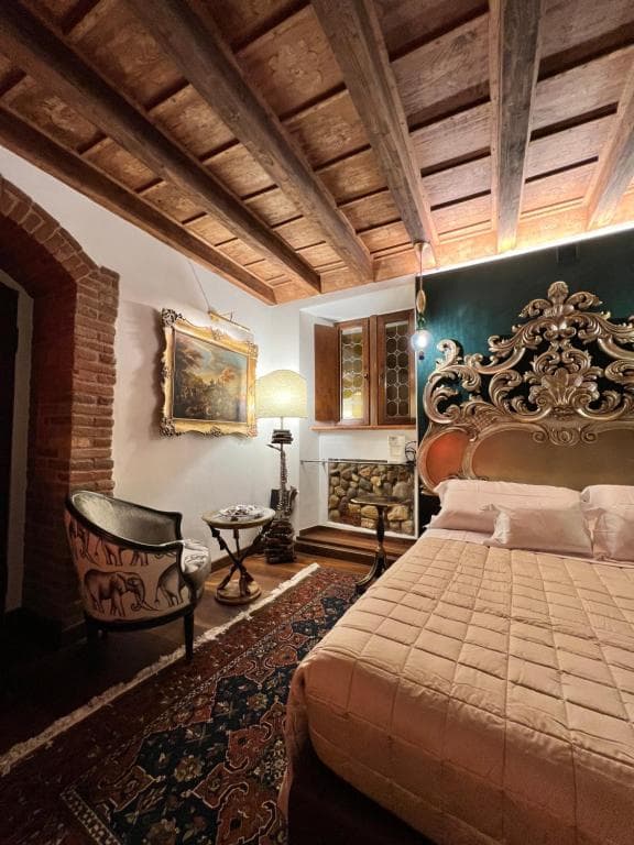 Suite con testiera barocca dorata e soffitto a travi a vista, Marcello Sleep & Spa a Verona