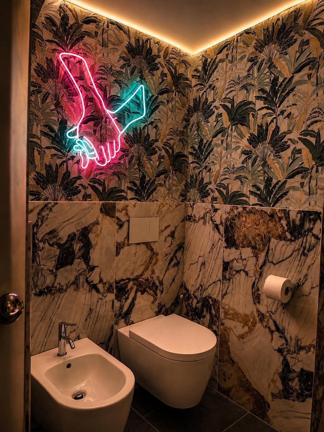 Detalle del baño privado Marcello en Verona en mármol Calacatta violeta con vetas doradas: lavabo ovalado blanco y encimera de mármol bajo el espejo barroco octogonal dorado